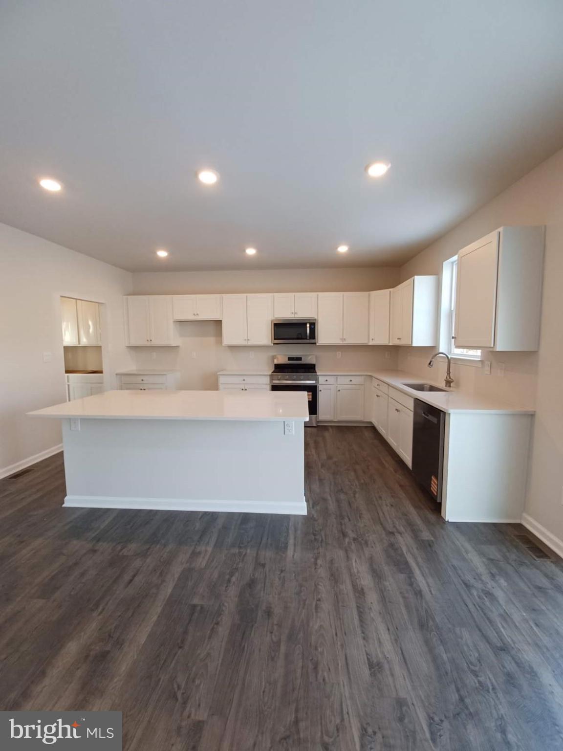 112 Winding Road Easton, PA 18040 - Photo 11 of 33 a large kitchen with kitchen island a stove a sink dishwasher and a oven with wooden floors