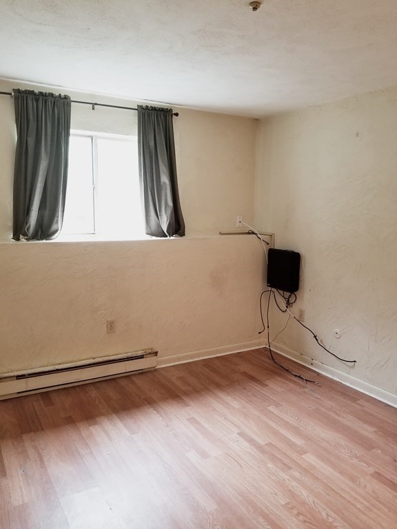 232 Swanson Road, Unit 628 Boxborough, MA 01719 - Photo 5 of 10 a view of an empty room with wooden floor and a window
