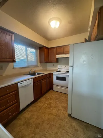 a kitchen with a refrigerator sink and cabinets