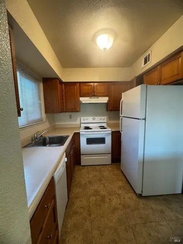 a kitchen with a refrigerator sink and cabinets