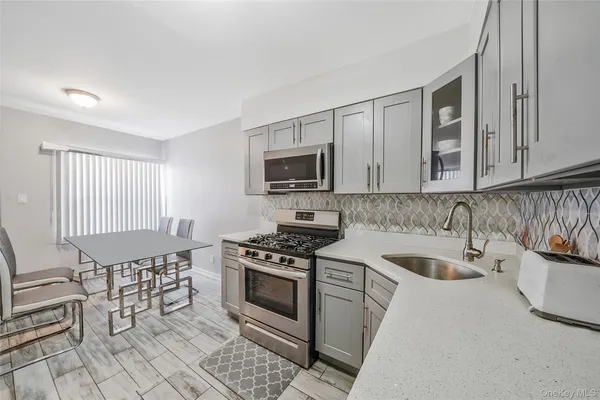 a kitchen with cabinets stainless steel appliances and a sink