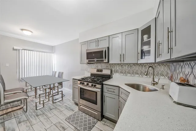 a kitchen with cabinets stainless steel appliances and a sink