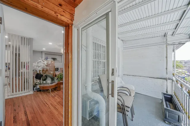 a view of a hallway with wooden floor and a bathroom