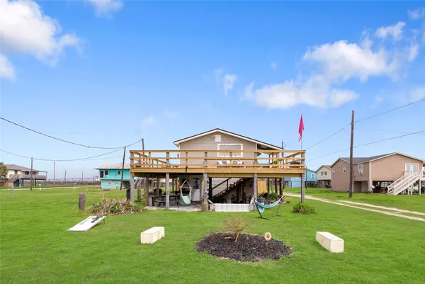 a view of a big house with a big yard and large trees