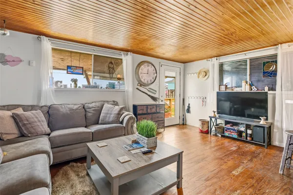 a living room with furniture a flat screen tv and a large window