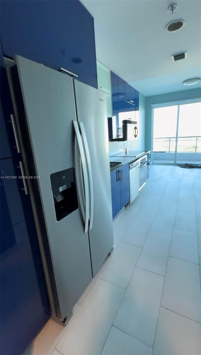 60 Southwest 13th Street, Unit 1219 Miami, FL 33130 - Photo 2 of 15 a kitchen with refrigerator and window