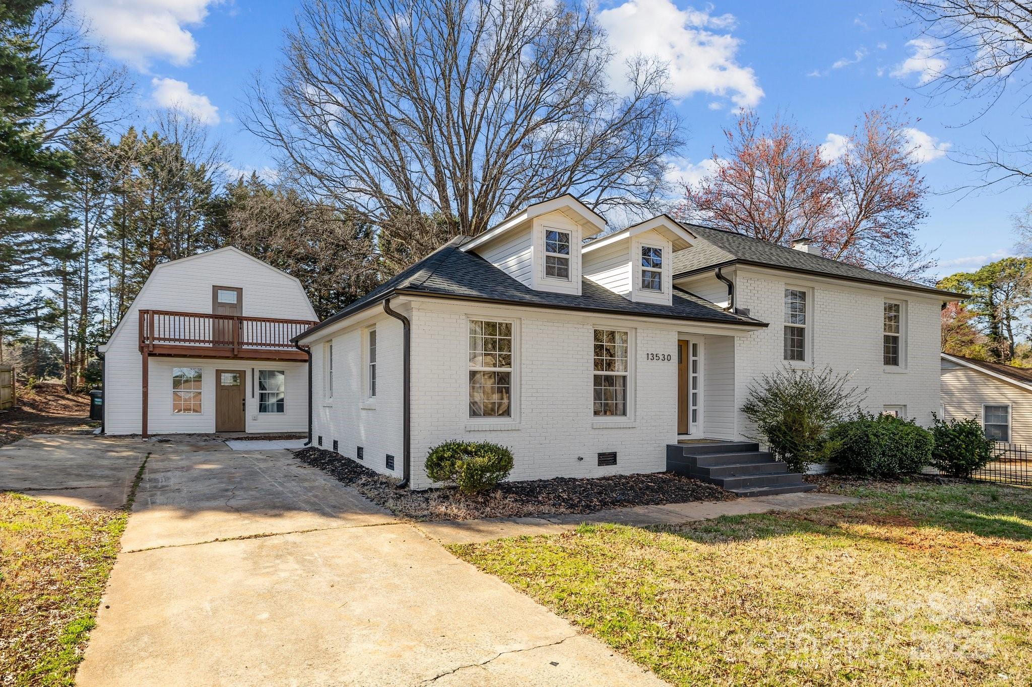 a front view of house with yard and trees around