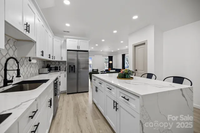 a kitchen with white cabinets sink and stainless steel appliances