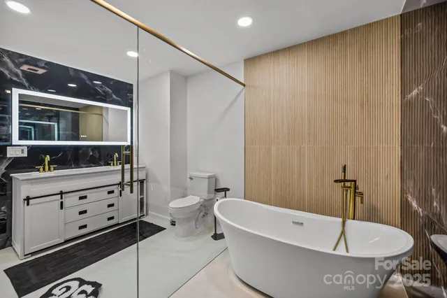 a bathroom with a tub a sink and mirror