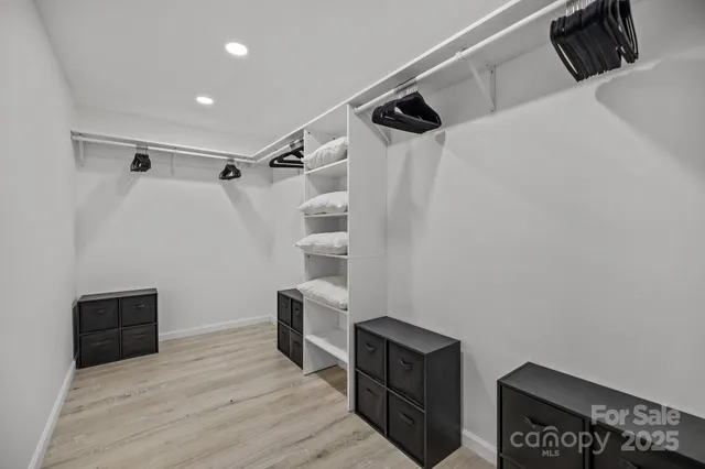 a view of walk in closet with clothes and shoes