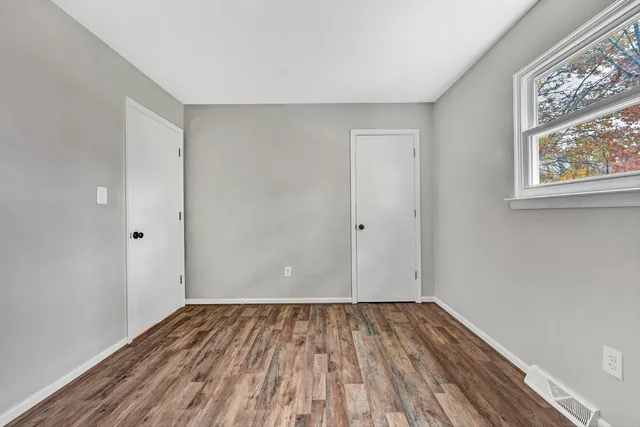 a view of a room with wooden floor and windows