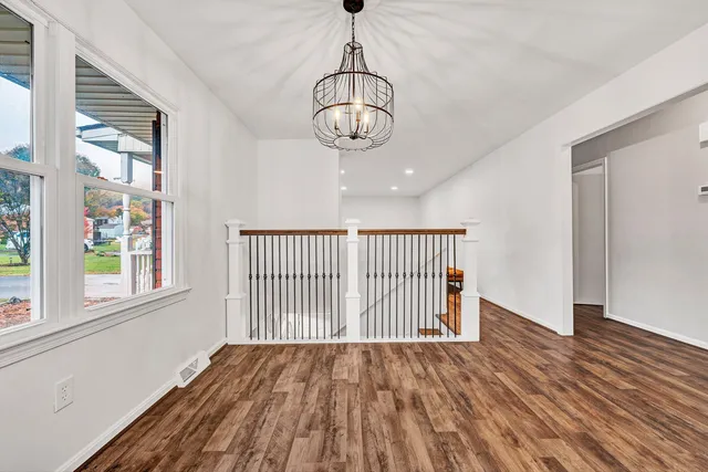 a view of a room with wooden floor windows and a chandelier