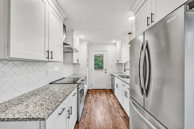 a kitchen with white cabinets and stainless steel appliances