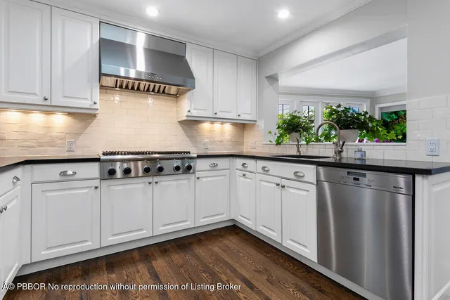 a kitchen with kitchen island a stove a sink and a microwave