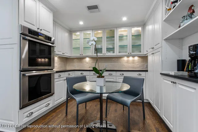 a bathroom with a toilet sink vanity and mirror