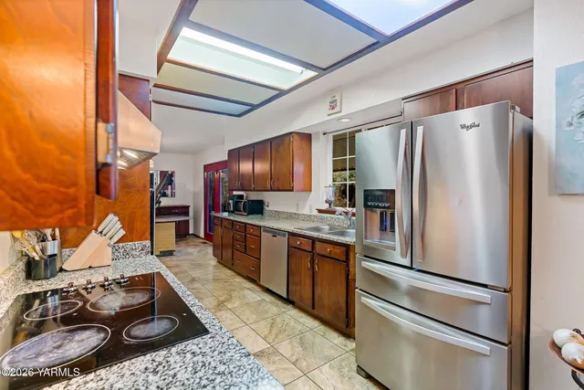 a kitchen with stainless steel appliances granite countertop a sink stove and cabinets