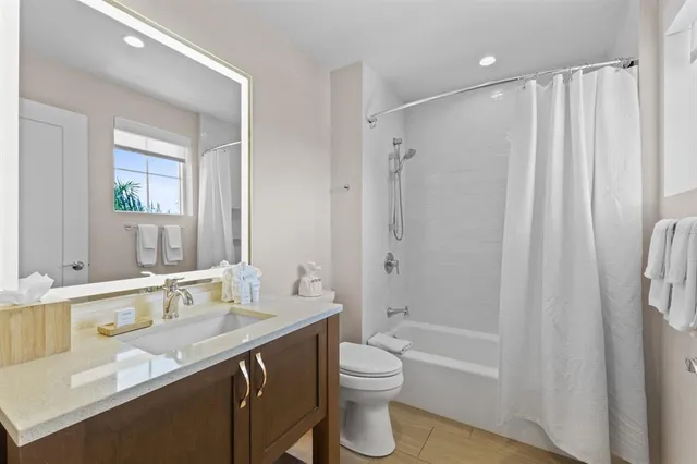 a bathroom with a granite countertop sink toilet and shower