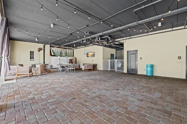 a outdoor space with lots of tables a window and chairs