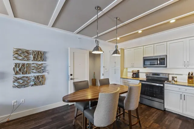 a kitchen with stainless steel appliances kitchen island granite countertop a sink cabinets and wooden floor