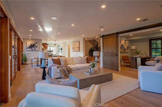 a living room with furniture kitchen view and a large window