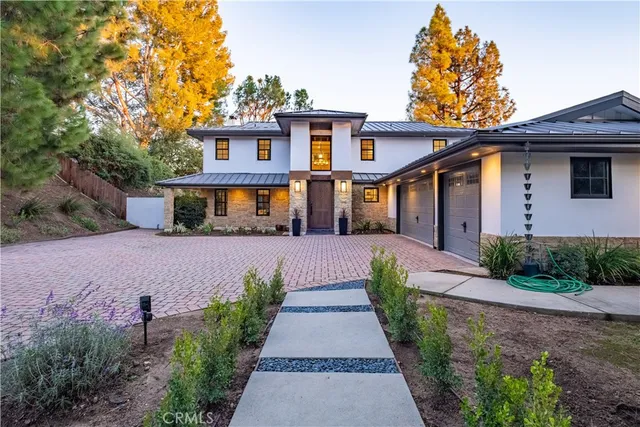 a front view of a house with a yard and potted plants