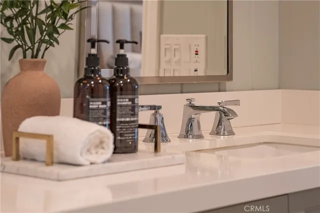 a view of a hallway with wooden floor and a bathroom