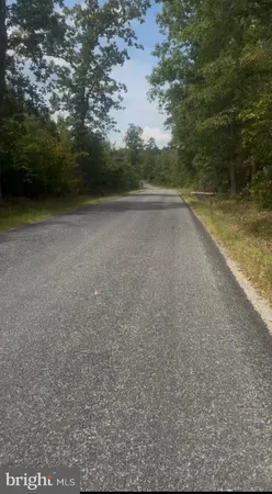a view of a green field with wooden fence