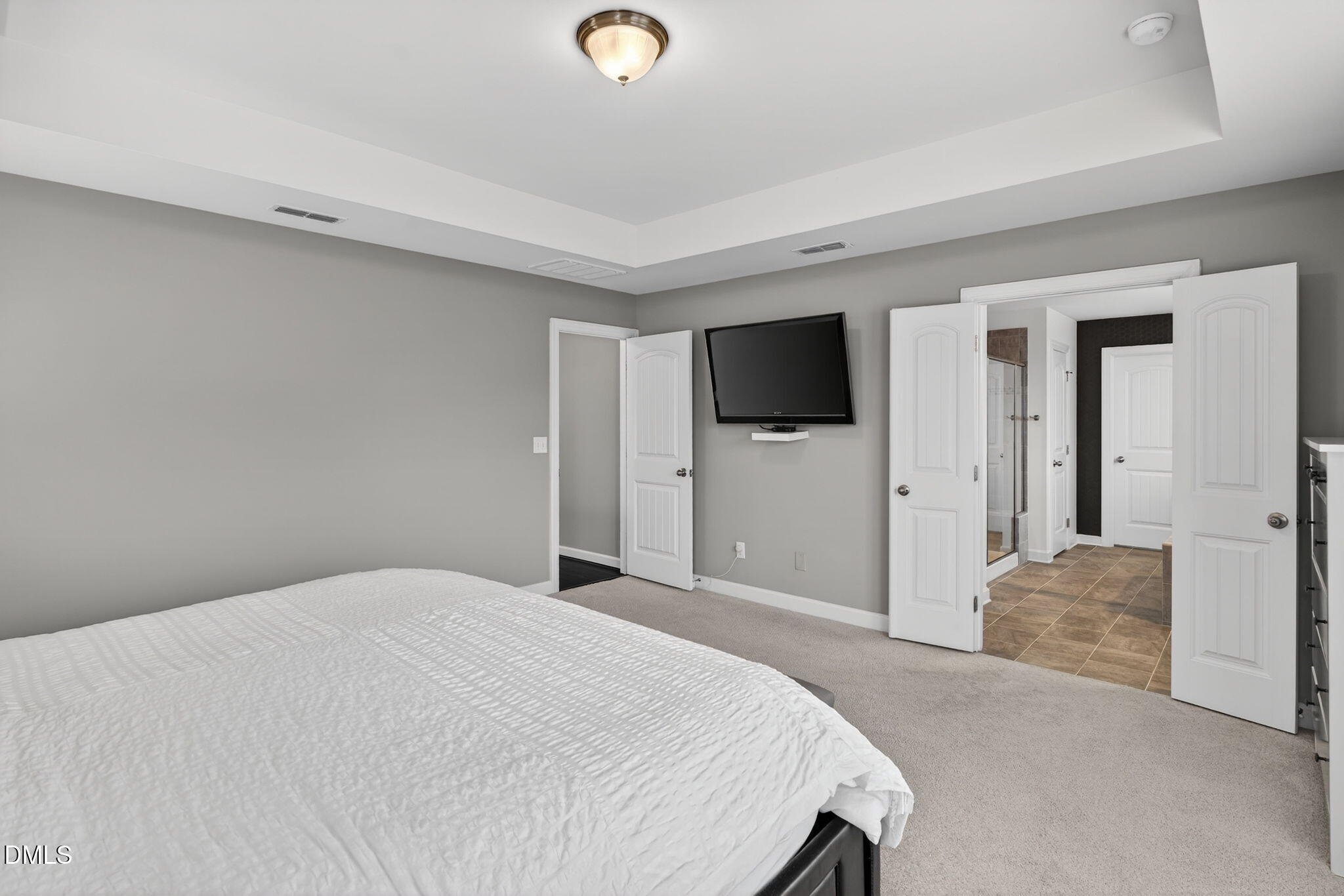 8001 Hergety Drive Raleigh, NC 27603 - Photo 27 of 52 a bedroom with a bed and a flat tv screen on wall