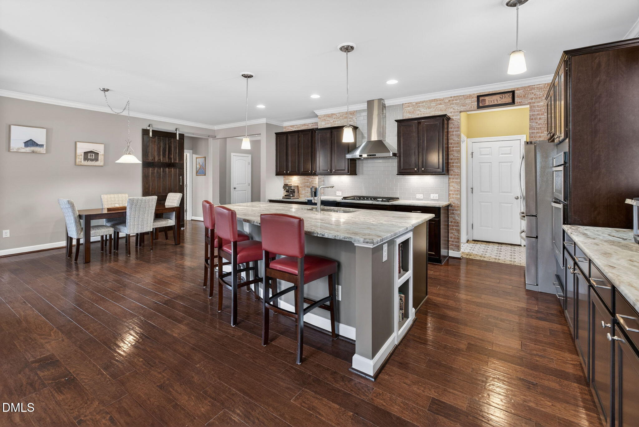 8001 Hergety Drive Raleigh, NC 27603 - Photo 6 of 52 a kitchen with stainless steel appliances a dining table chairs stove refrigerator and cabinets