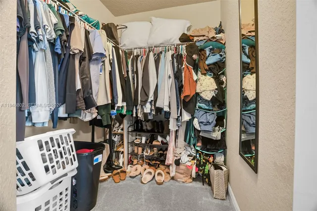 a view of walk in closet with clothes