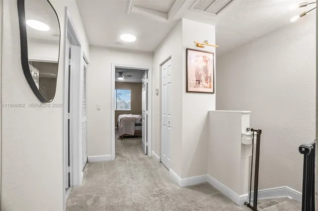 a view of a hallway with a livingroom and a window