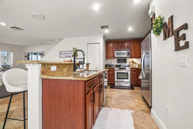 a kitchen with stainless steel appliances granite countertop a stove and a sink