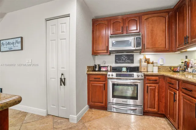a kitchen with stainless steel appliances granite countertop a stove and cabinets