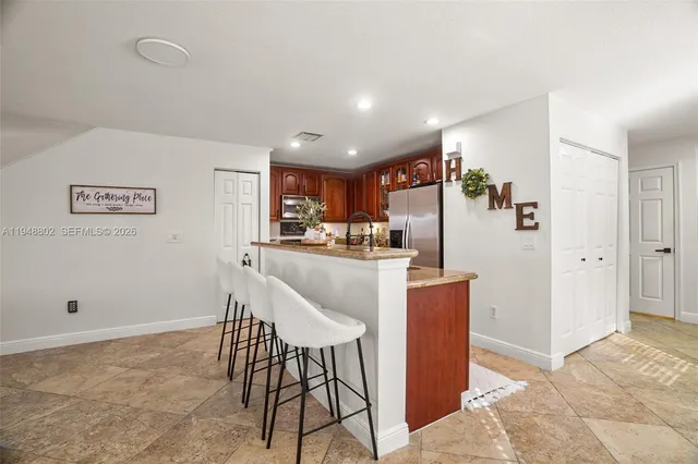 a kitchen with stainless steel appliances granite countertop a refrigerator and a stove top oven