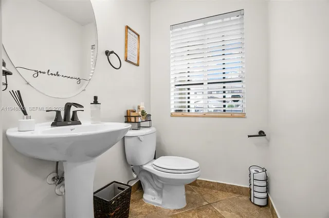 a bathroom with a toilet a sink and mirror