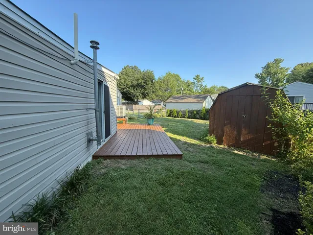 a house that is sitting in the grass with large trees