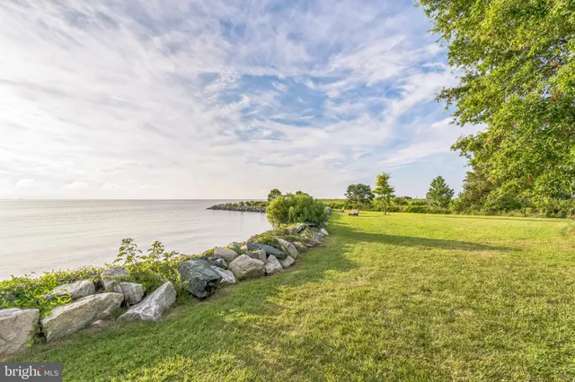 a front view of a house with a garden and trees