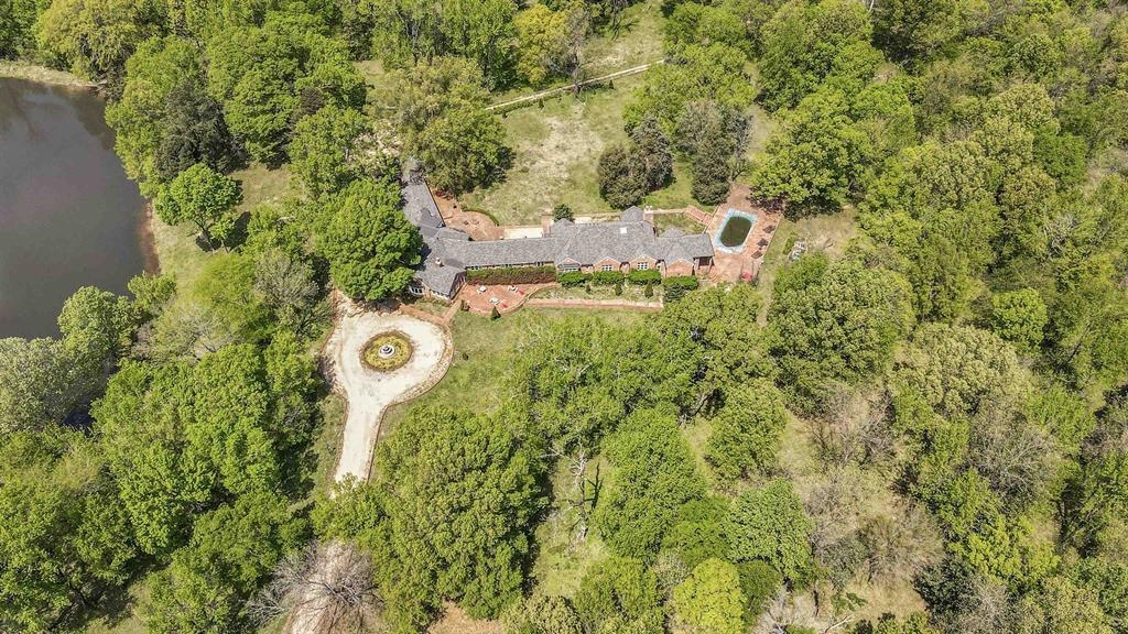 530 West Raines Road Memphis, TN 38109 - Photo 6 of 38 Expansive wooded property featuring a brick residence with a dark-pitched roof, an outdoor swimming pool, and an adjacent pond