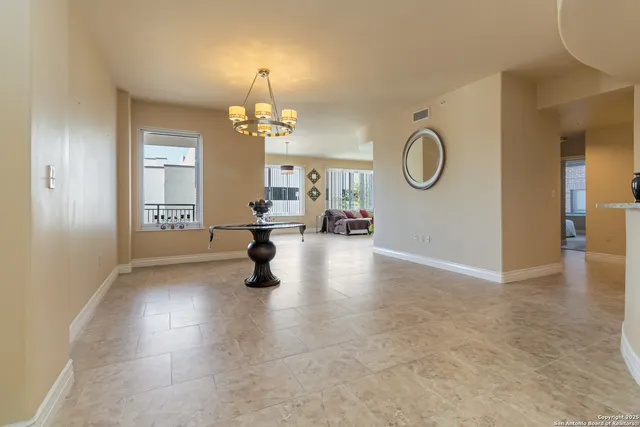 a view of a livingroom with a chandelier and wooden floor