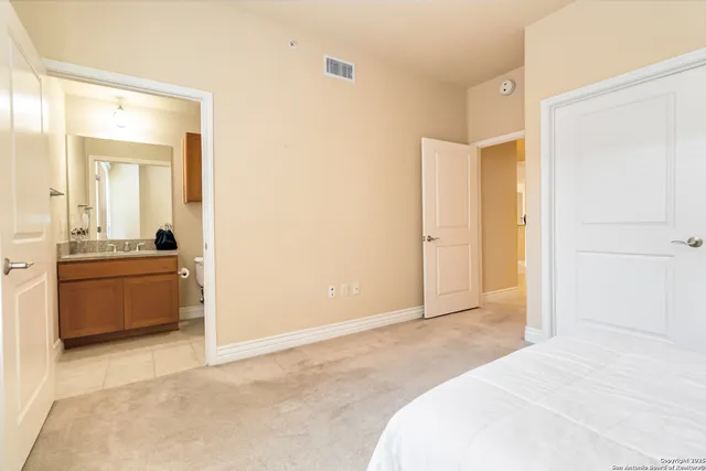 a bathroom with a granite countertop toilet sink and mirror