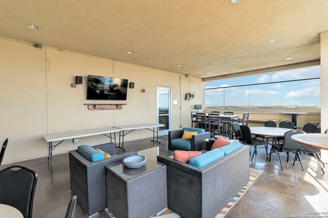a living room with lots of furniture and a floor to ceiling window