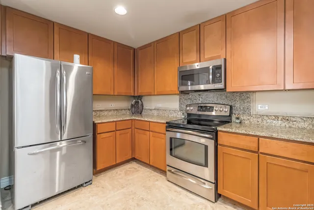 a kitchen with granite countertop cabinets stainless steel appliances and a sink