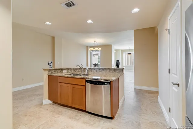 a view of kitchen with stainless steel appliances granite countertop a refrigerator a stove a sink and a microwave