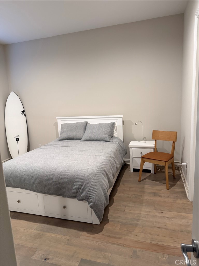 1018 11th Street Manhattan Beach, CA 90266 - Photo 21 of 29 a spacious bedroom with a bed and a wooden floor