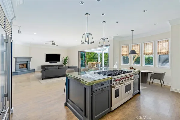 a kitchen with a stove and a flat screen tv