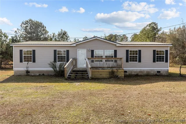 a view of a house with a patio and a yard