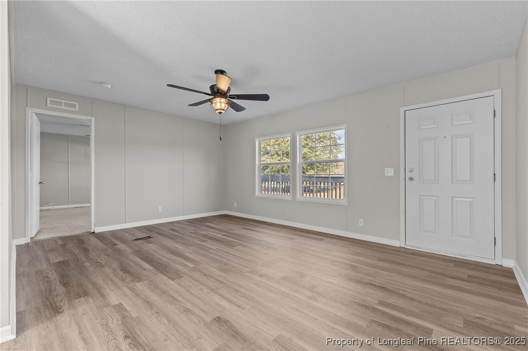 670 Bear Bay Road Lumberton, NC 28358 - Photo 9 of 25 an empty room with wooden floor and windows