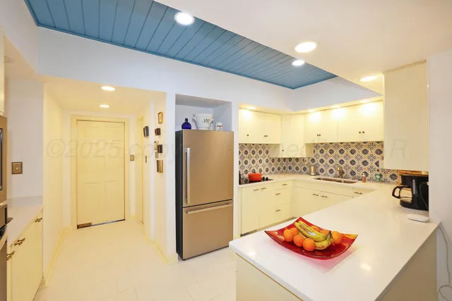 a kitchen with refrigerator and cabinets