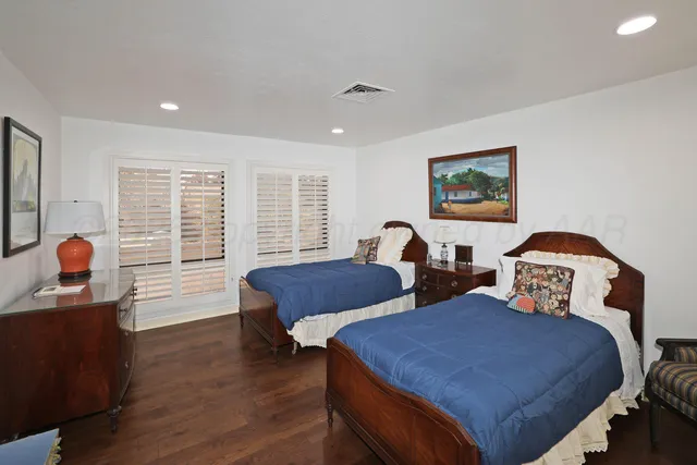 a bedroom with two beds and a large window