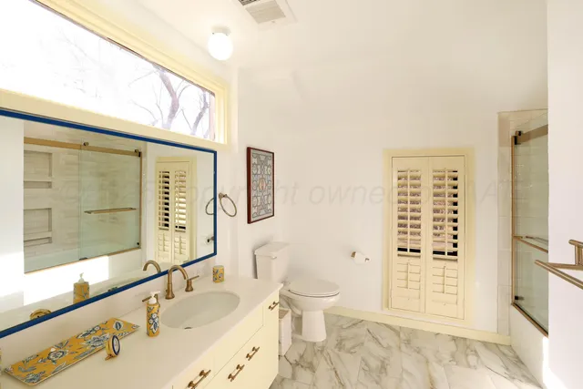 a bathroom with a sink a toilet and shower